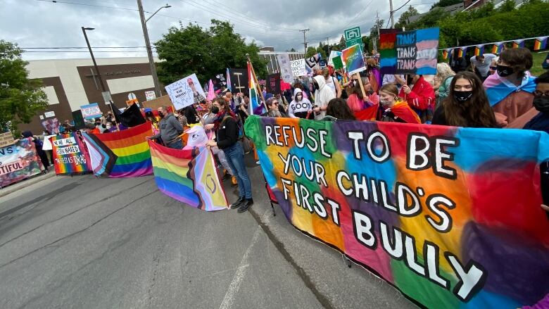 A group of people stand with banners.