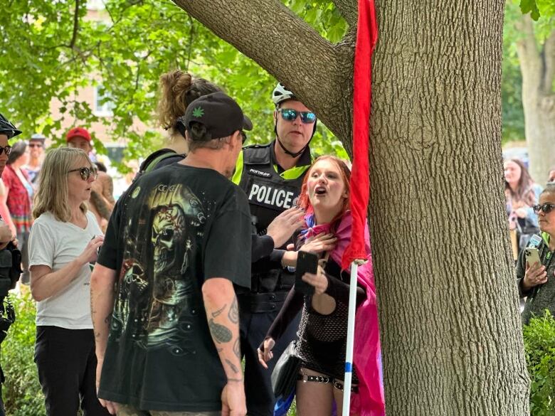 An LGBTQ activist present at Saturday's Wortley Pride festival confronts a protester while being held back by police and others.