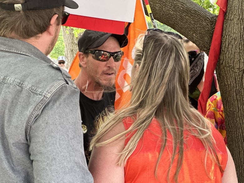 A protester, seen wearing glasses and facing the camera, faces off against an activist at the corner of Wortley Road and Elmwood Avenue on Saturday.