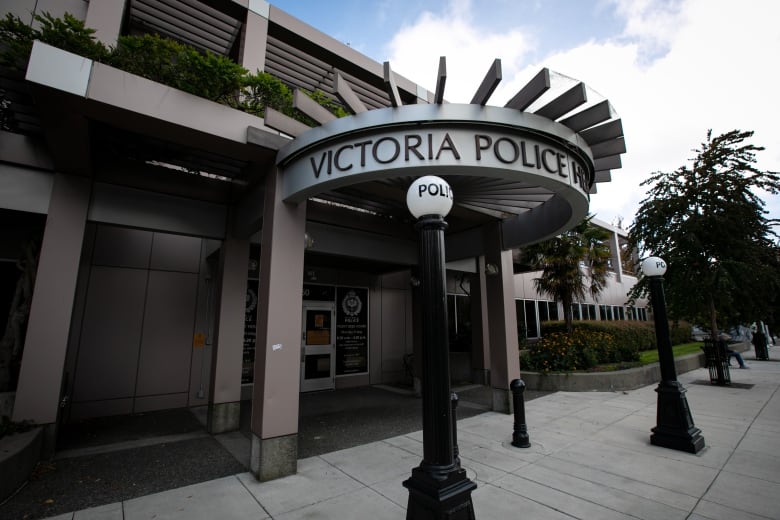 The exterior of the building of the Victoria Police Department shows a circular facade, with the words 'Victoria Police Headquarters' and two bollards that have circular tops with the words 'Police' on them.