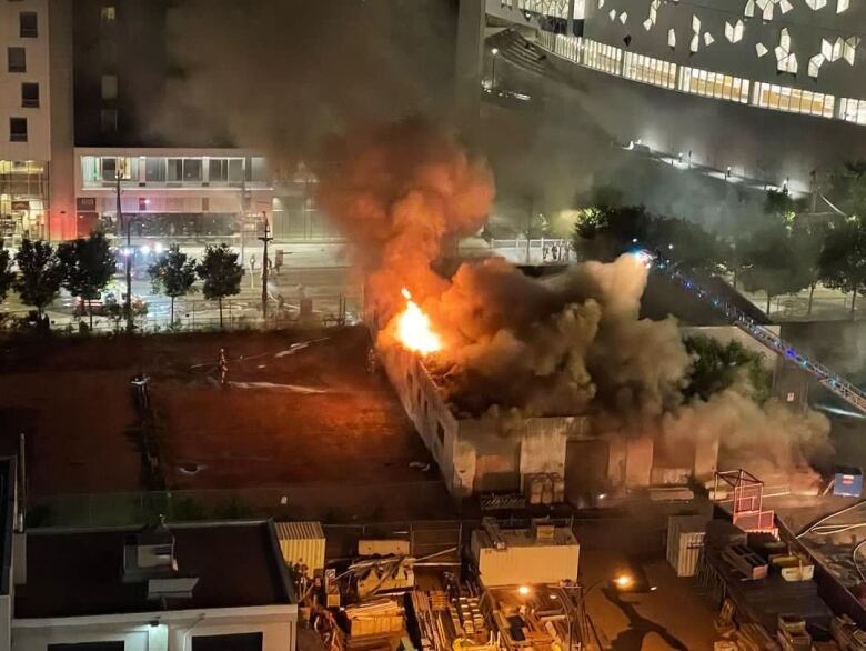 An aerial view of fire fighters battling an active fire at a two-storey warehouse building.