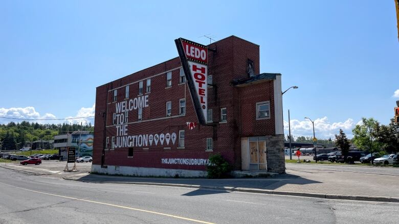 A three-storey brick building with a sign that says Ledo Hotel.