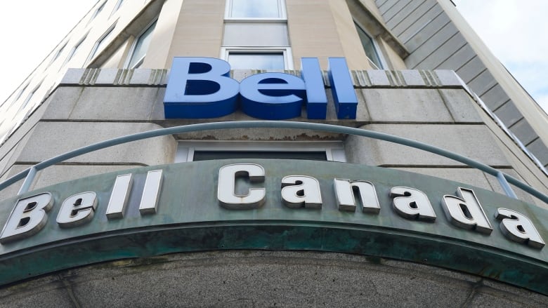 A blue sign on a building that reads BELL and BELL CANADA