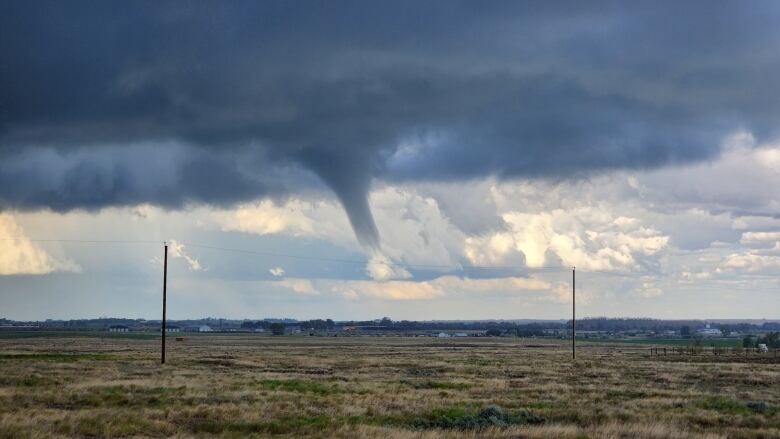 A tornado is visible in the sky.