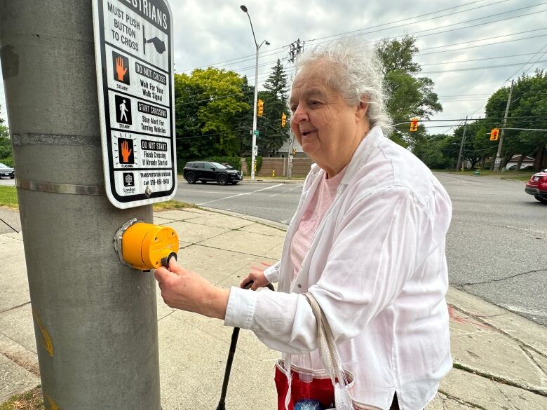 women pushes button at intersection