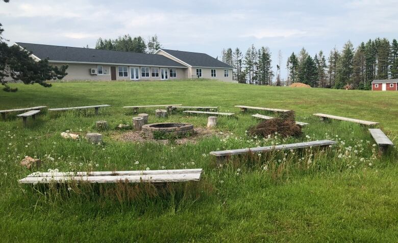 A campfire ring in the middle of a grassy field. 