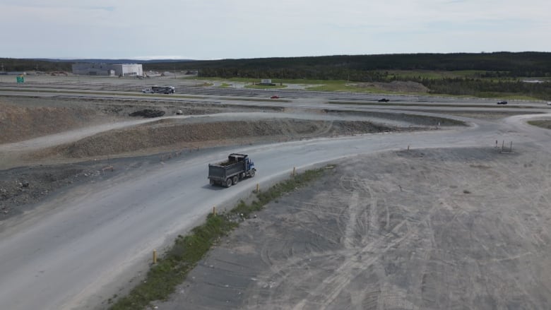 an aerial photo of a dump truck passing through a construction site