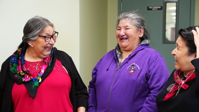 A group of Innu women smile and laugh together. 