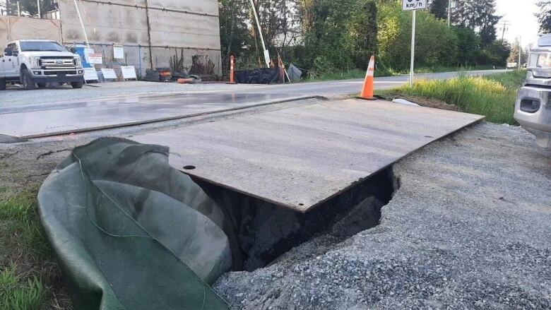 Metal plates cover part of a sinkhole.