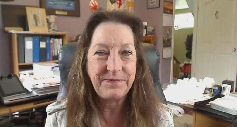 A woman sits in her mayor's office looking at the camera