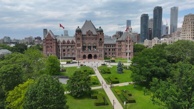 Queen's Park seen from the air, with lush trees and grass out front.