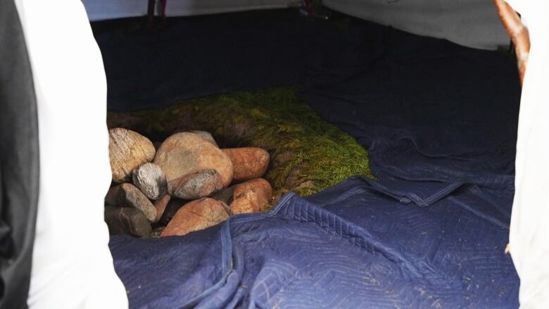 A group of stones are in the centre of a circular tent. 