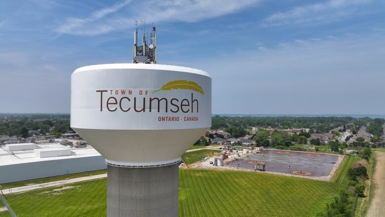 An aerial view of a large white water tower that says Town of Tecumseh Ontario Canada.