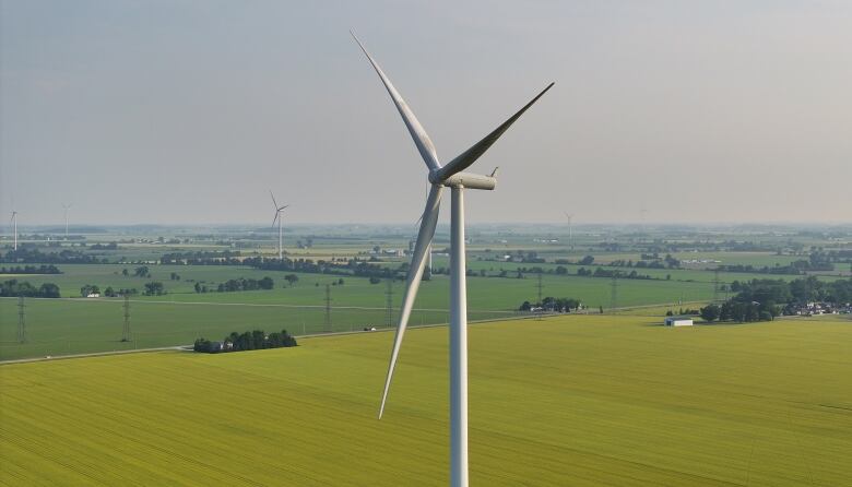 A large windmill is centred in the photo, with more windmills in the distance.