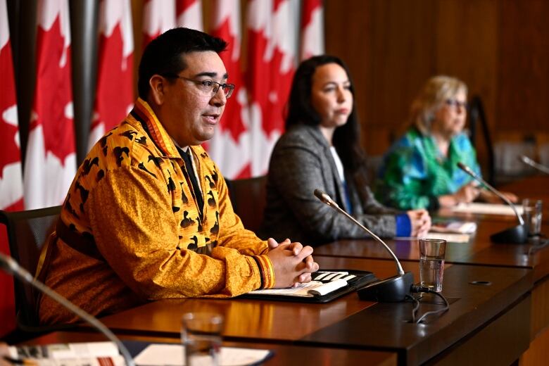 A First Nations chief speaks at a table during a news conference.