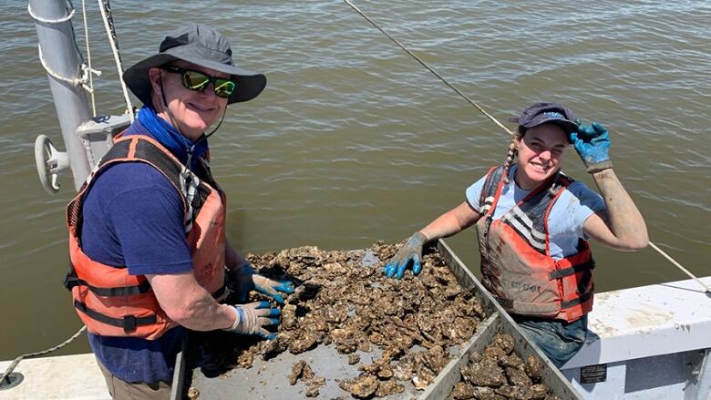 Ryan Carnegie collecting oysters with a student.