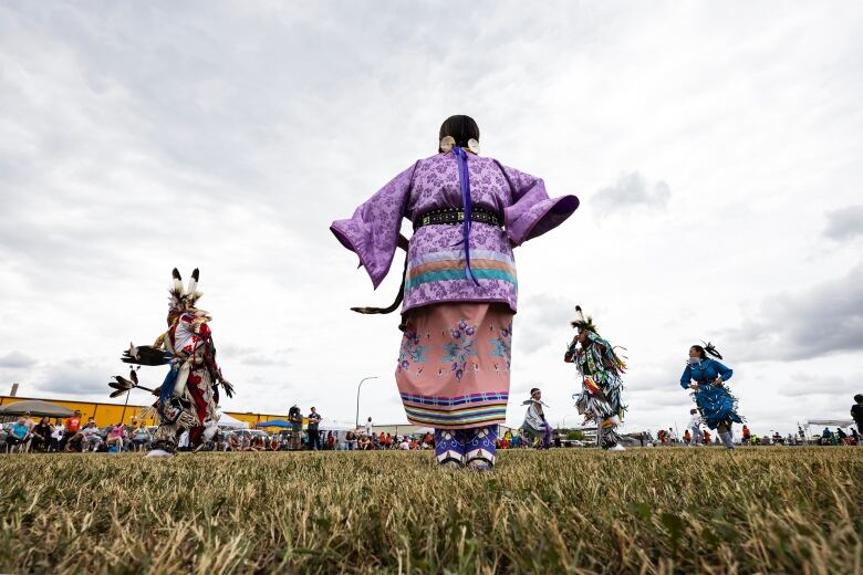 Powwow dancers perform while wearing traditional First Nations regalia. 