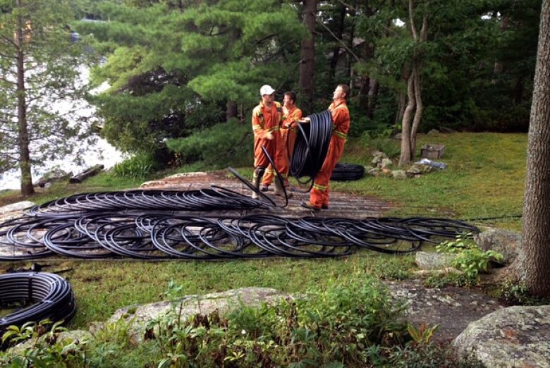 Contractors unwind piping on a lakefront property.