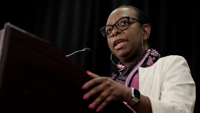 A woman speaking at a microphone.