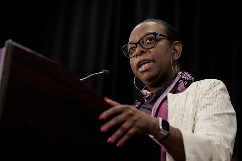 A woman speaking at a microphone.