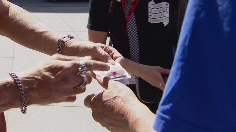 A man is handed harm reduction supplies.