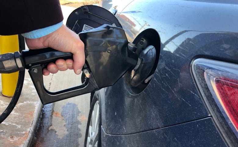 A driver fills car at gas station. 