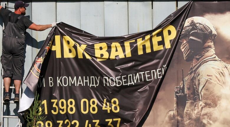 A worker removes an advertising banner