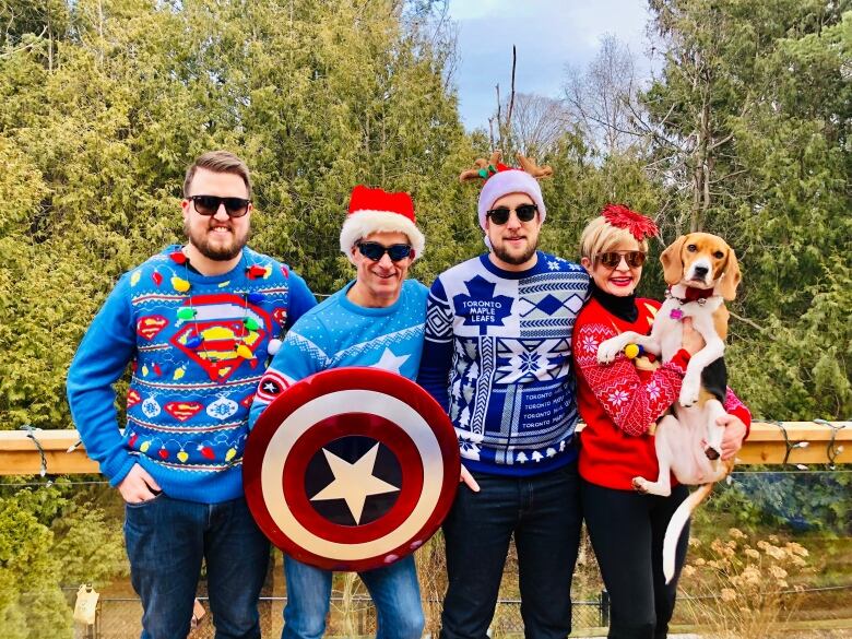 Ryan and his family pose for a photo with Christmas sweaters on. 