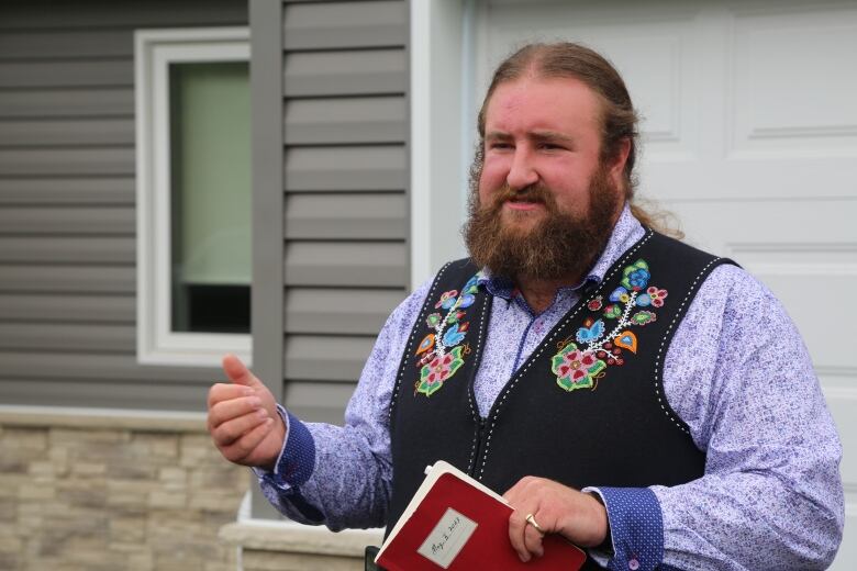 A person speaking with a book in his hand.