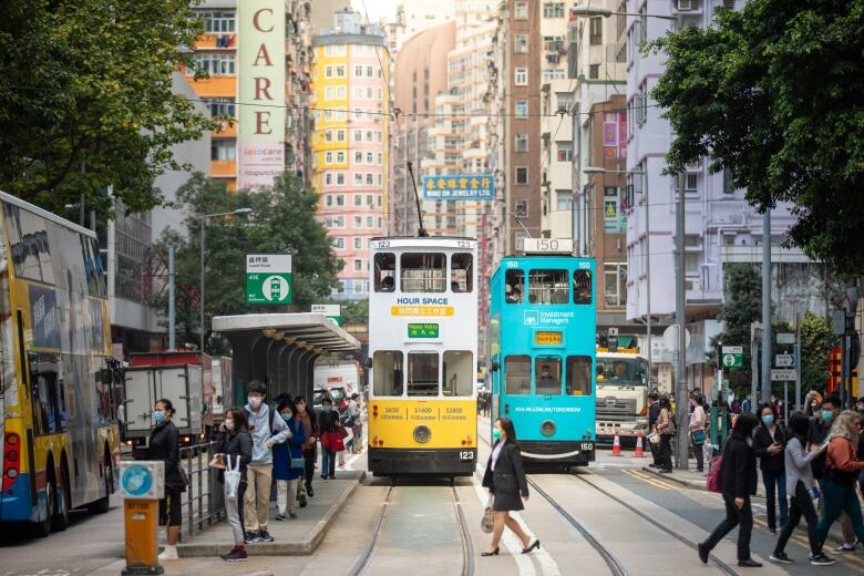 A busy cityscape with people and streetcars.