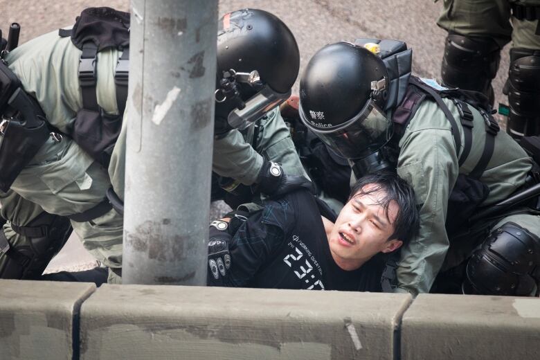 Police arrest a young protester.