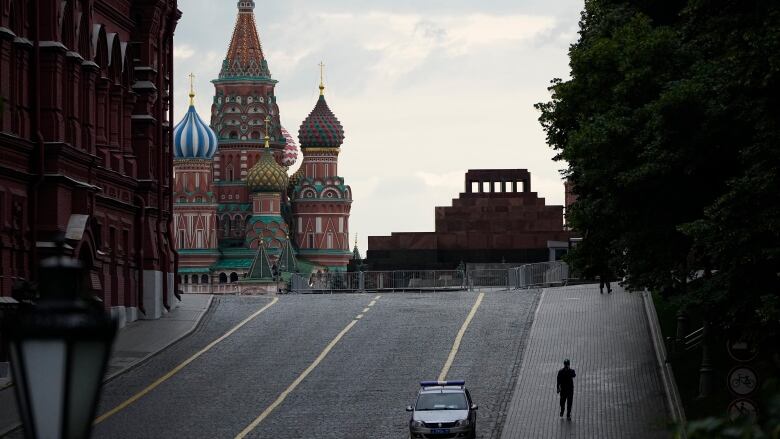 A man walks from an empty Red Square with the St. Basil's Cathedral and Lenin mausoleum in the background in Moscow, Russia, on Wednesday.