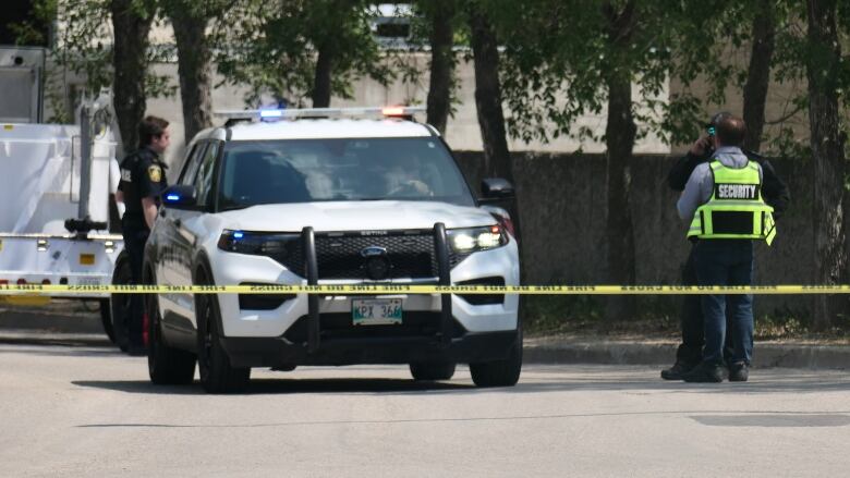 A police car behind police tape. 