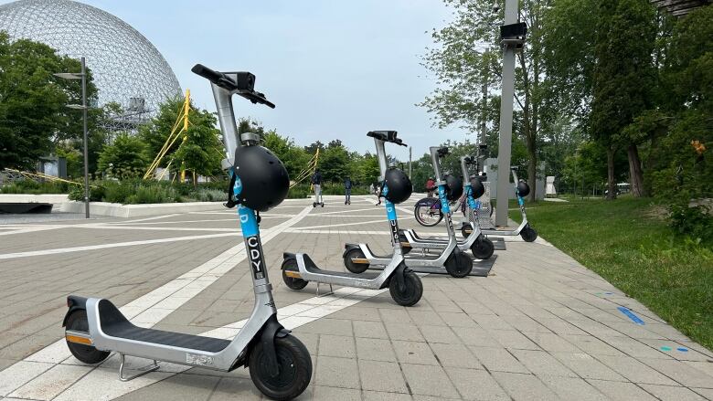 e-scooters in front of the biosphere at Montreal's Parc Jean-Drapeau