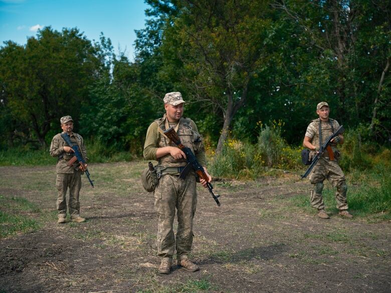 Soldiers train in a forest.