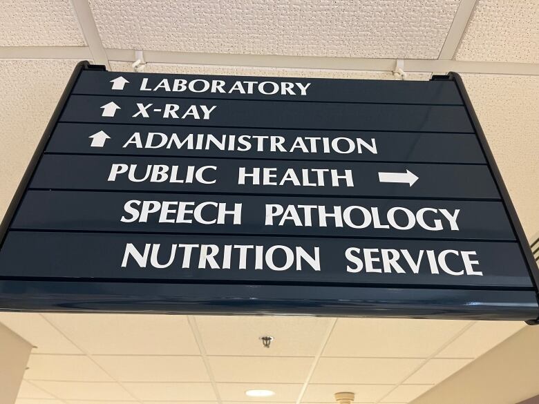 A hospital sign directs patients to various wings of the hospital.