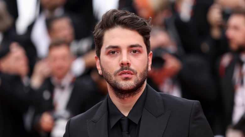 Xavier Dolan poses for photographers upon arrival at the 76th Cannes Film Festival. 