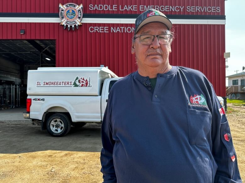 A man stands in front of a fire hall.