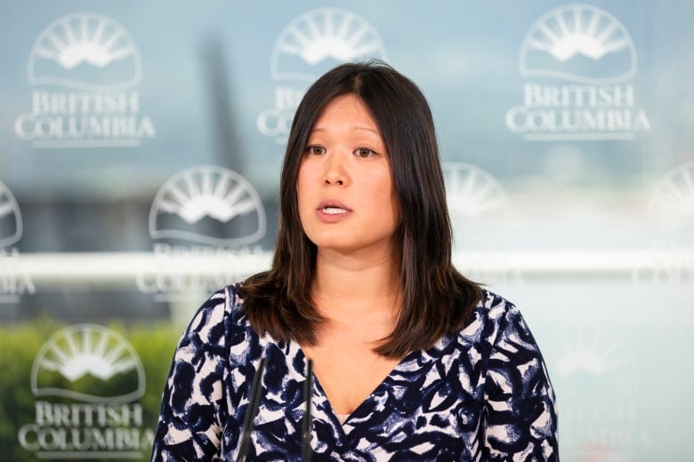 An East Asian woman speaks at a news conference.