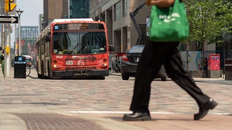 A bus with an electric sign saying it's out of service waits at a red light.