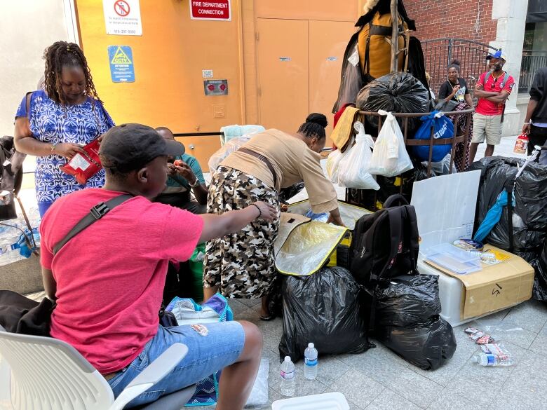 Asylum seekers wait outside a shelter in Toronto's downtown core.