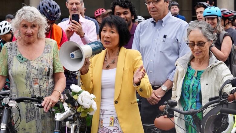 Olivia Chow, centre, was joined by dozens of supports as she cycled to city hall Wednesday morning to be sworn in as Toronto's next mayor.