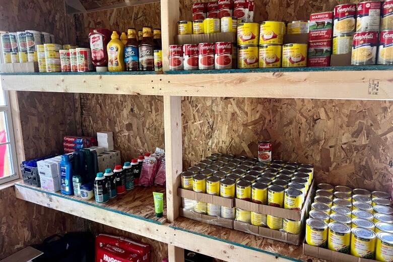 Canned food and toiletries line two large shelves.