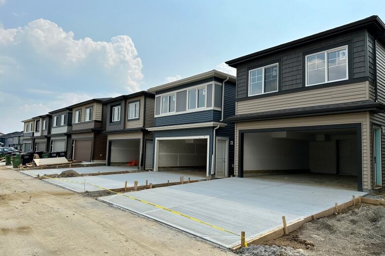 A row of garages with garden suites on top.