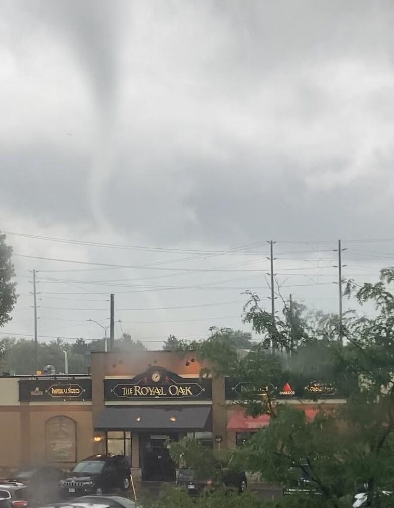 A tornado behind a building.