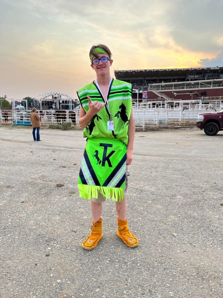 Joshua stands in the grass dressed in bright green ahead of competition.