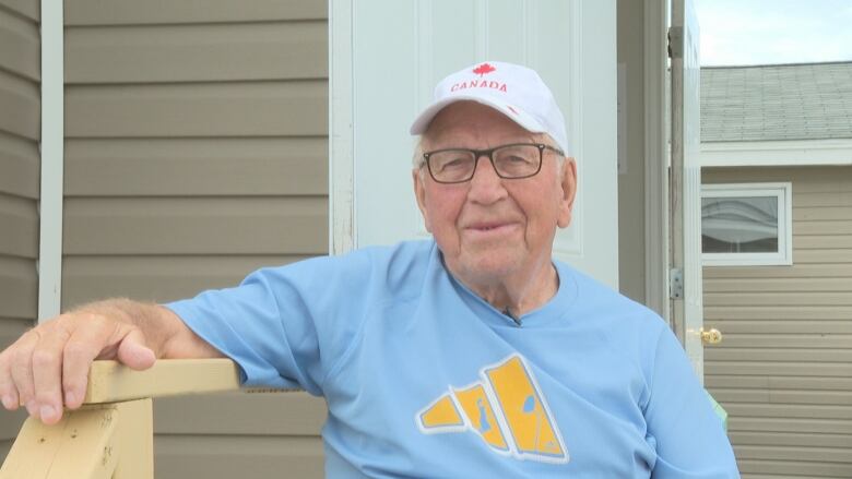 An old man sits on his porch.