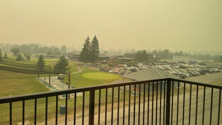 A smoky sky seen from a balcony casts a dull yellow pall over Prince George.