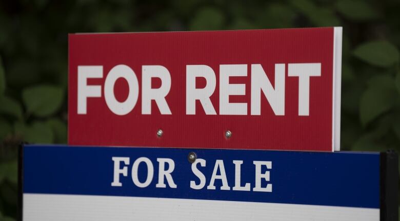 A real estate lawn sign displays a banner that reads 