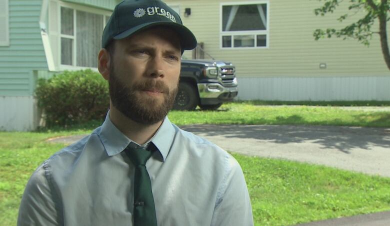 A man with a beard wears a ballcap.